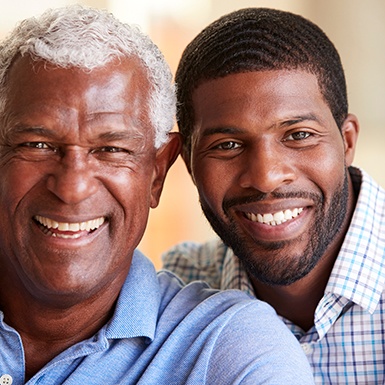 Adult man and his father sitting and smiling together