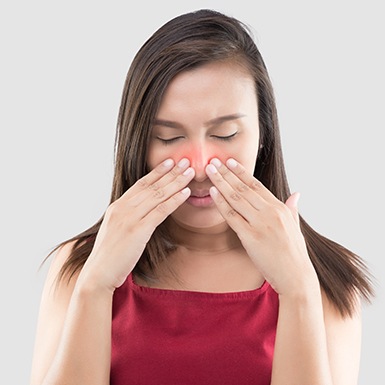 Woman in red shirt with nasal congestion