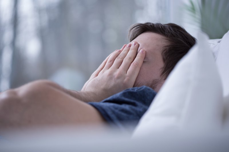 A man trying to wake up after a disturbed sleep due to sleep apnea