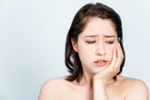 Woman with jaw pain holding her face