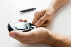 Person with diabetes using monitor to check blood glucose